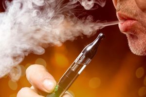 37732607 – close up portrait of a man smoking an e-cigarette